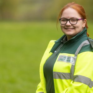 Anastasija Seglina, a young woman with red hair wearing yellow and green ambulance PPE.