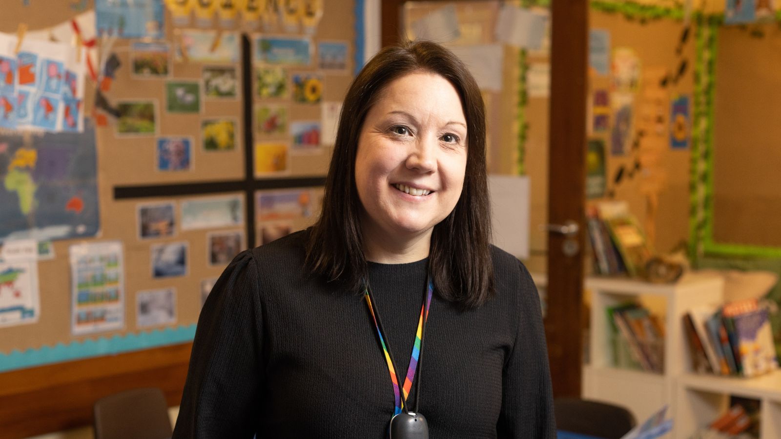 Smiling lady in a school wearing a lanyard.