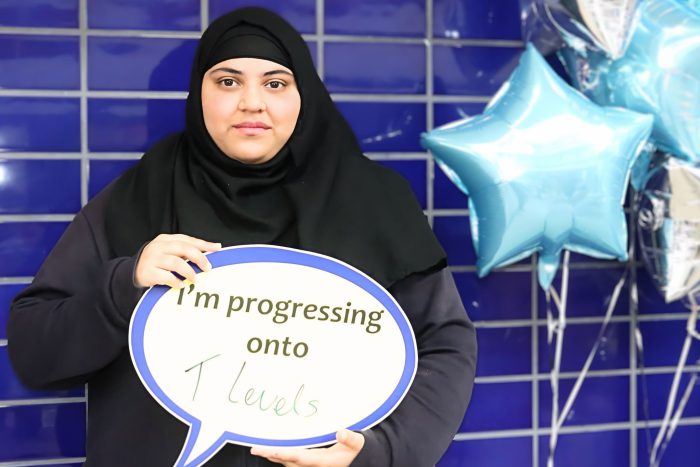 Young lady holding a board that reads 'I'm progressing onto T Levels'