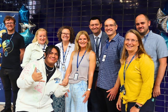 A smiling group of people of various ages.