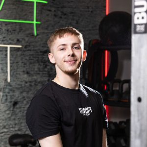 Young man stood in front of medicine balls.