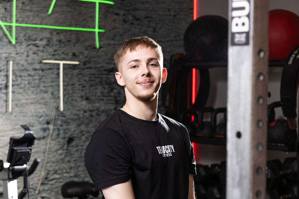 Young man stood in front of medicine balls.