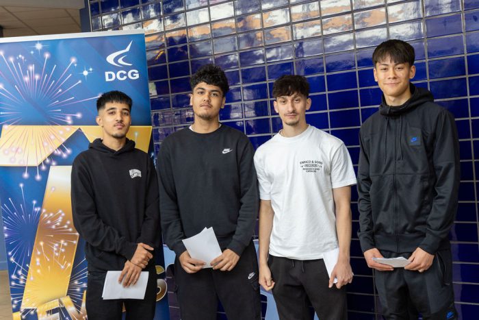 Four T Level Business, Management & Administration students holding their results.