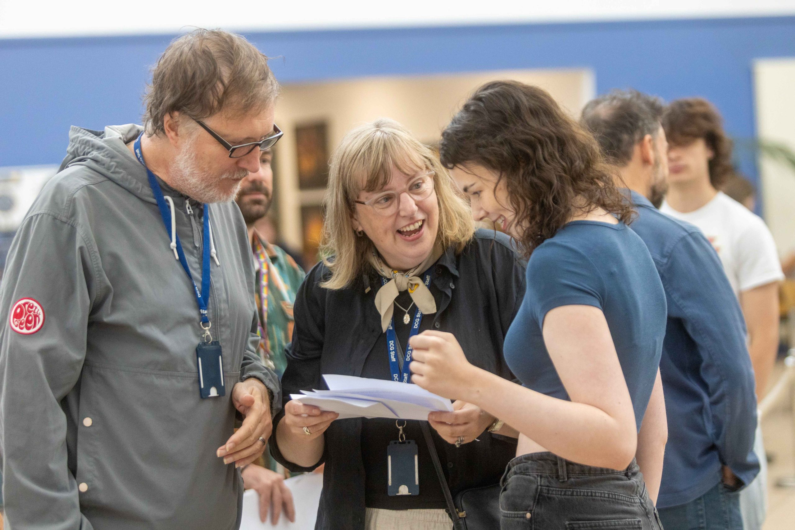 Young student Eleanor showing her results to two teachers.