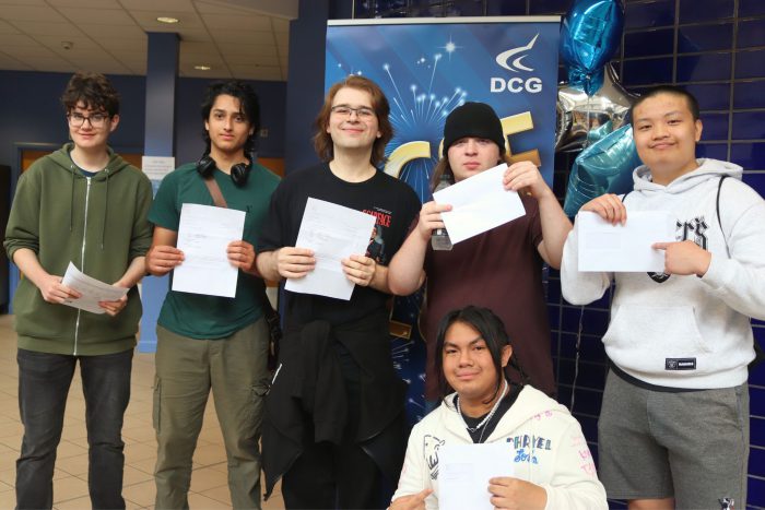 A group of young males holding results certificates.