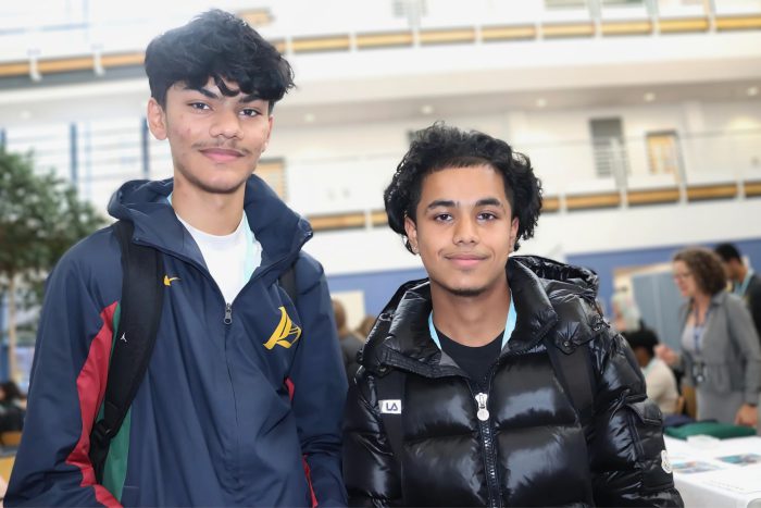 Two smiling young men at Derby College Group's Joseph Wright Centre wearing blue lanyards