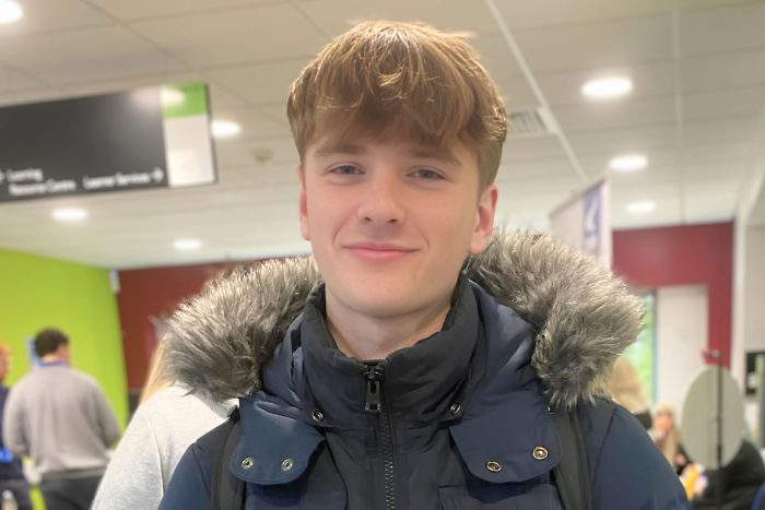 Smiling young man wearing a blue coat.