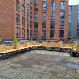 A paved garden with wooden benches and planters.